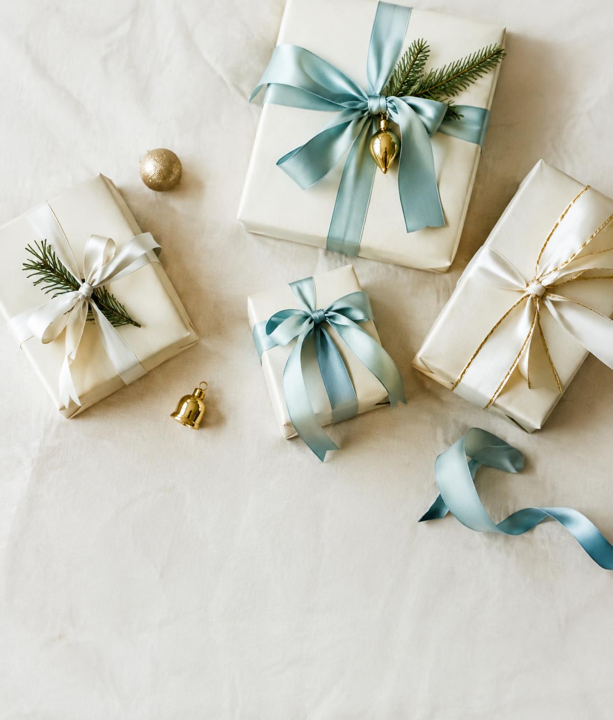Gifts wrapped in cream paper with sea-glass blue and ivory silk ribbons